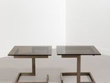 une paire de tables basses noires en verre et métal, avec des pieds carrés