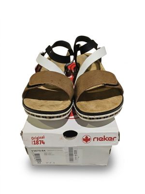 une paire de sandales marron et blanches posée sur une boîte