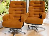 une paire de fauteuils orange devant une grande fenêtre dans un salon