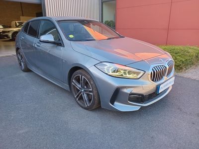 the bmw m140i is parked in front of a building