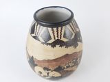 a small vase with a painting on it on a white surface