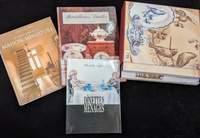 Plusieurs livres sont posés sur une surface noire, sur fond noir.