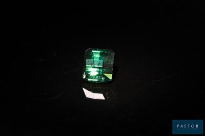 une pierre d'émeraude verte sur un fond noir