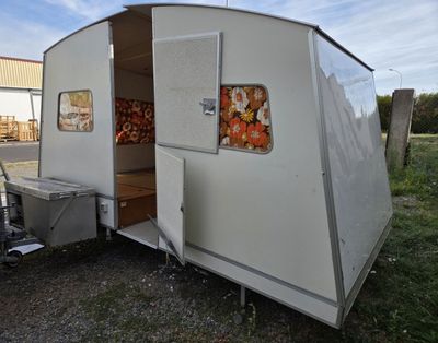 a small white trailer with a kitchen inside of it