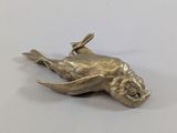 brass plated bird on a branch on a white surface
