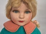 a close up of a doll with blonde hair and blue eyes