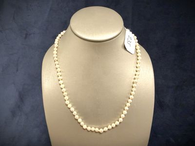 a close up of a necklace on a mannequin with a tag
