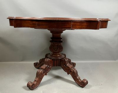 une vieille table en bois dont le plateau est sculpté sur fond blanc