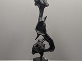 a black and white photo of a sculpture of a bird on a rock
