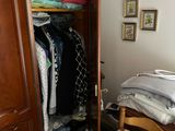 une armoire pleine de vêtements et une chaise dans une pièce