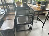 des tables et des chaises dans une pièce où se trouve une plante sur le rebord de la fenêtre