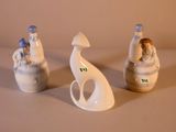 trois figurines assises l'une à côté de l'autre