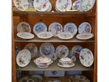 de nombreuses assiettes et bols posés sur une étagère dans un placard