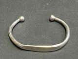 a close up of a silver bracelet on a black surface