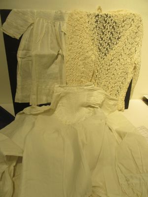 a bed with a lot of white clothes on it