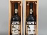 two bottles of wine are in a wooden box on a gray surface