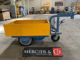 un chariot jaune et bleu sur lequel est accrochée une pancarte