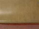 a close up of a brown leather seat on a wooden bench