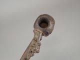 a small pipe that is on top of a wooden stick