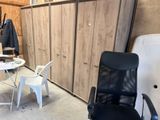 une photo d'une pièce avec un bureau, une chaise et des armoires