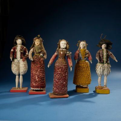 Plusieurs figurines de tailles et de couleurs différentes sont disposées sur un fond bleu