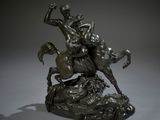 statue en bronze représentant un homme à cheval sur un rocher