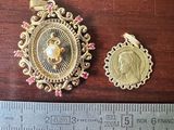 two pieces of gold are shown next to a ruler on a wooden table