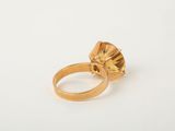 a close up of a gold ring with a yellow topaz stone