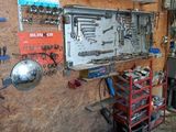 un garage équipé d'un établi et d'outils accrochés au mur