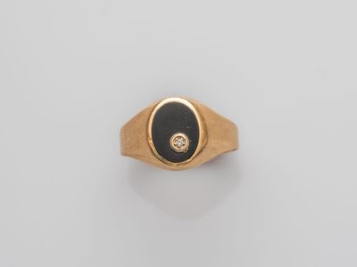 a gold ring with a black stone and a diamond