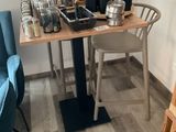 une petite table sur laquelle se trouve une cafetière, dans un coin de la pièce