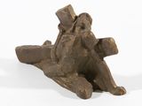 statue d'un homme portant une croix sur le dos, posée sur une surface blanche