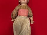 an old doll is laying on a red surface with a red background