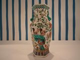 a vase with a painting on it sitting on a table