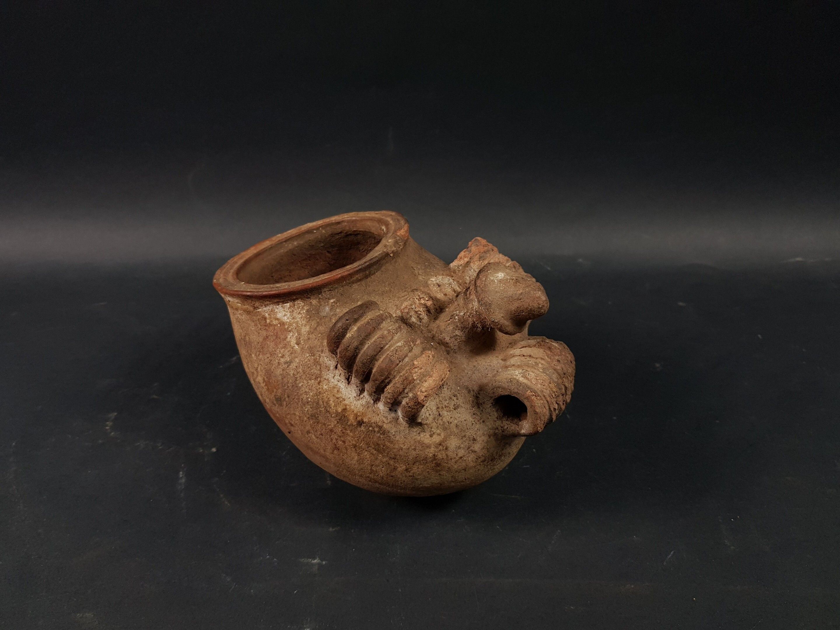 Pot Izzi, Nigeria Terre-cuite Ancien pot rituel à trois anses Igbo-Izzi figurant une bouche ouverte, surmonté d'une p...