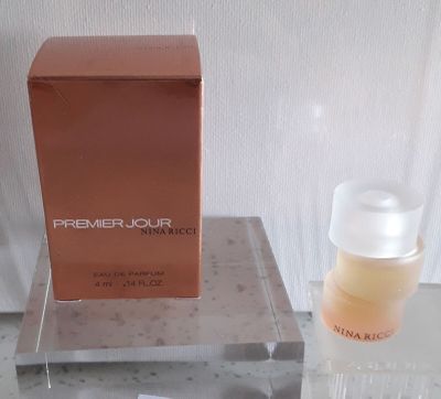 un flacon de parfum posé sur une table à côté d'un autre flacon de parfum