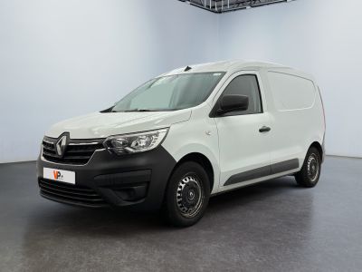 La camionnette blanche est garée dans une grande pièce.