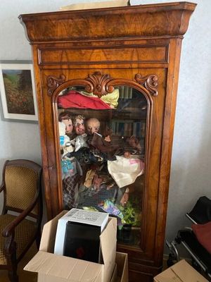 a cabinet that has a doll in it and a box in front of it