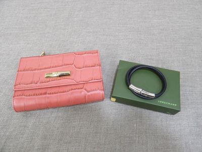 a pink purse and a green box on a bed