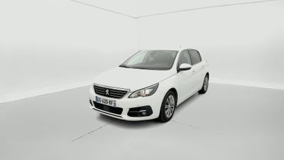 Une voiture blanche est garée dans une pièce blanche au sol blanc.