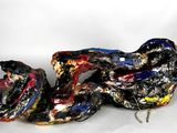 une sculpture représentant un serpent allongé sur le sol