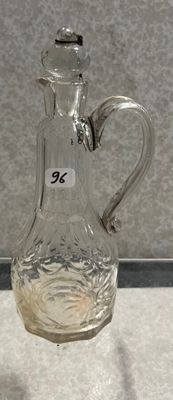 un pichet en verre transparent muni d'une anse, posé sur une table