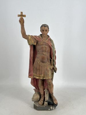statue d'un homme tenant une croix dans la main droite et une autre croix dans la main gauche