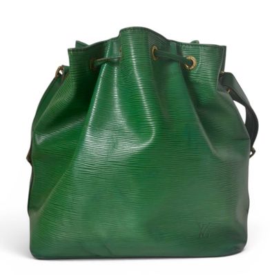a green bucket bag sitting on top of a white surface