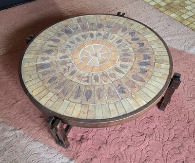 une table ronde dont le plateau est orné d'une mosaïque