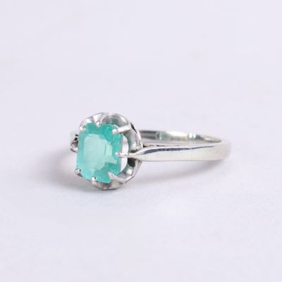 a close up of a ring with a green stone in it