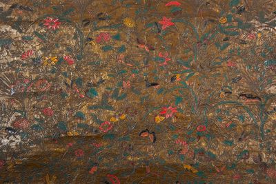 a painting on the wall of a room with birds and flowers