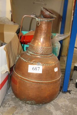 a large copper pot sitting on the floor next to a box