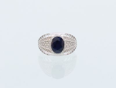 une image représentant une bague ornée d'une pierre noire sur un fond blanc
