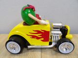 a yellow toy car with a green apple on top of it